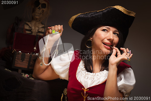 Image of Dramatic Female Pirate Biting A Coin