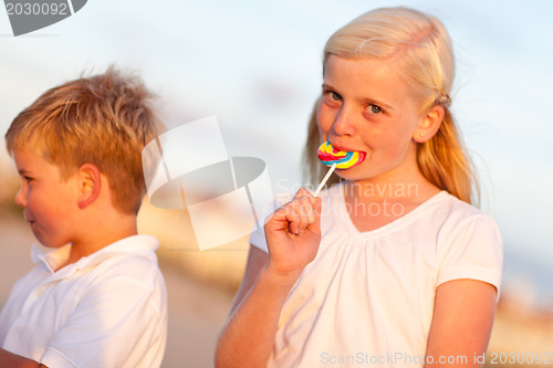 Image of Cute Little Girl and Brother Enjoying Their Lollipops