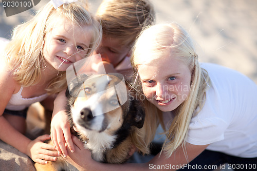 Image of Cute Sisters and Brother Playing with Dog