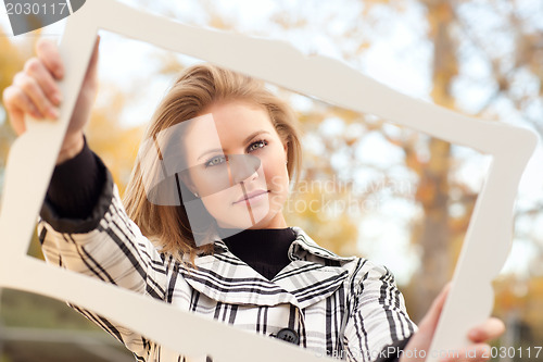 Image of Pretty Young Woman Smiling in the Park with Picture Frame