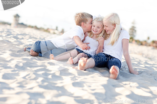 Image of Adorable Sibling Children Kissing the Youngest