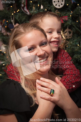 Image of Adorable Son Hugging His Mom in Front Of Christmas Tree