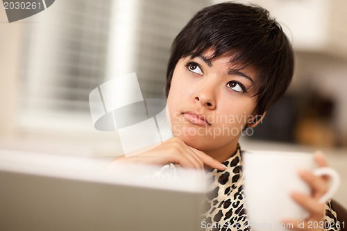 Image of Pretty Mixed Race Woman Holding Cup Using Laptop