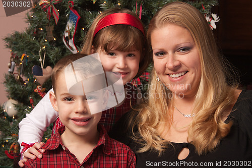 Image of Cute Children and Mother Posing in Front Of Holiday Tree