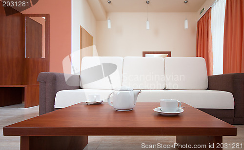 Image of Teapot and cups on the background of the sofa