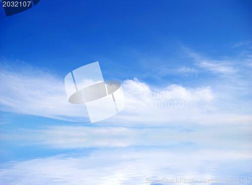 Image of white fluffy clouds with rainbow in the blue sky