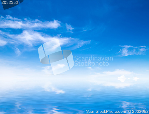 Image of white fluffy clouds with rainbow in the blue sky