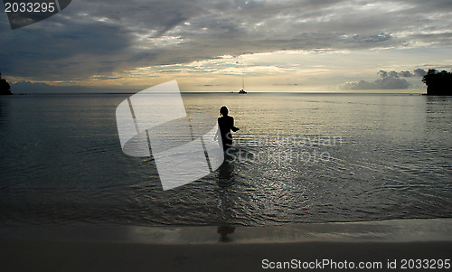 Image of Silhouette of a woman walking into the sea