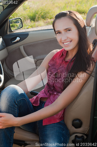 Image of Smiling brunette woman in car