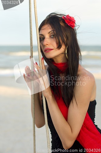 Image of charming young woman sitting on a swing