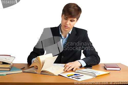 Image of cute man reading a book at table