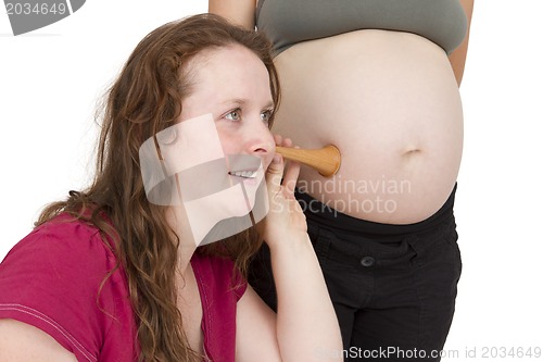 Image of midwife listening at human belly