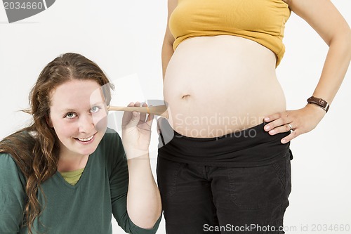 Image of midwife listening at human belly