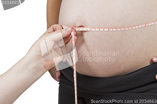 Image of hand of midwife measuring pregnant belly