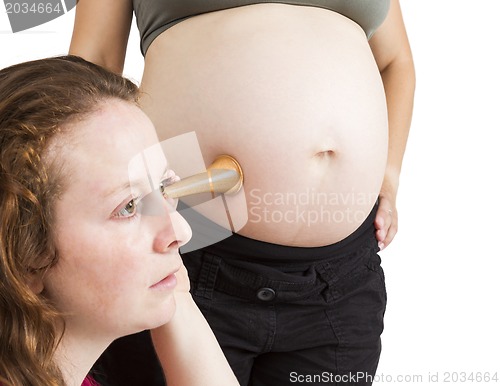 Image of midwife listening at human belly