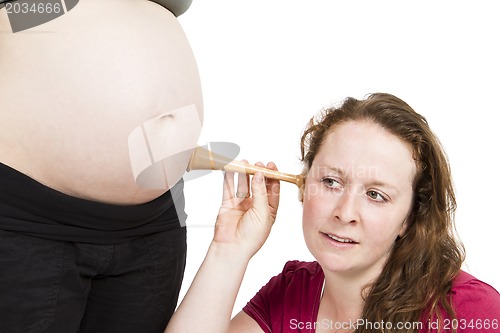 Image of midwife listening at human belly