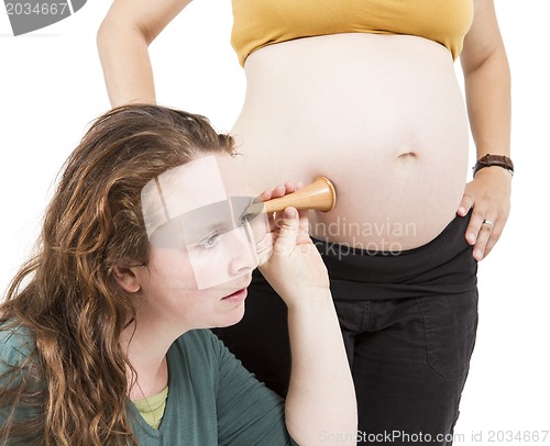 Image of midwife listening at human belly