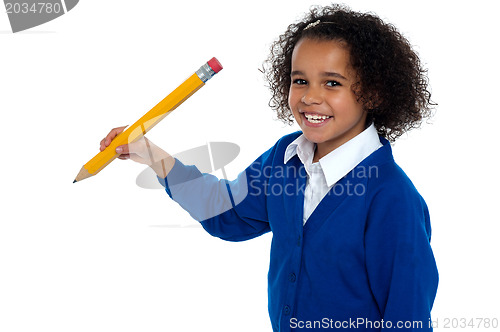 Image of Pretty school kid facing camera with pencil in hand