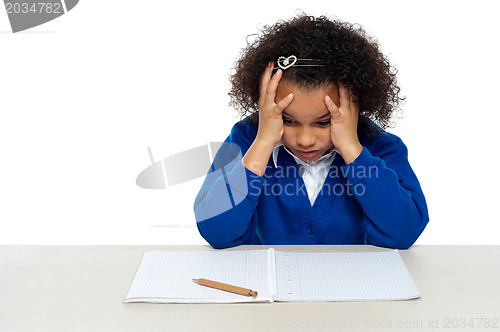 Image of Stressed out primary girl child holding her head