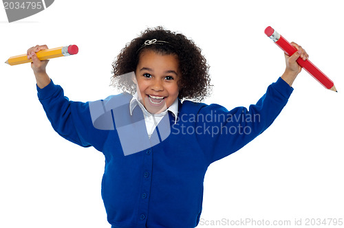 Image of Fun loving elementary girl dancing with pencils in both her hands