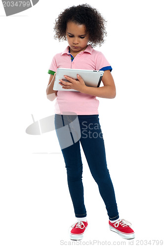 Image of Young girl super busy in operating new tablet device