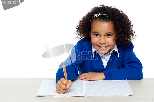 Image of Cute primary kid writing her assignment