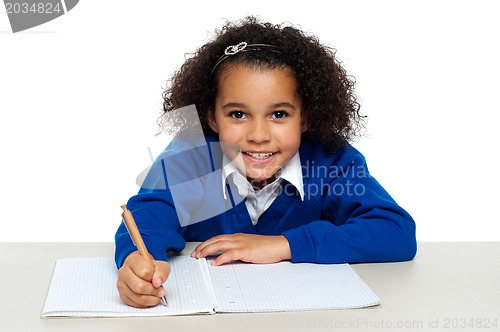 Image of Young girl writing copying notes from the whiteboard