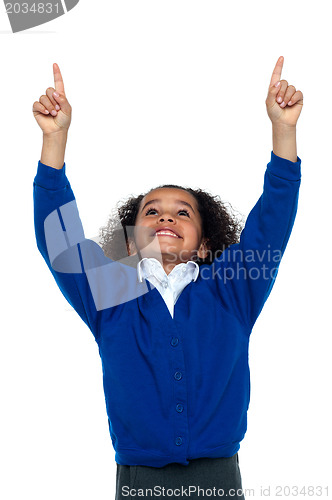 Image of Amazed young school girl indicating upwards