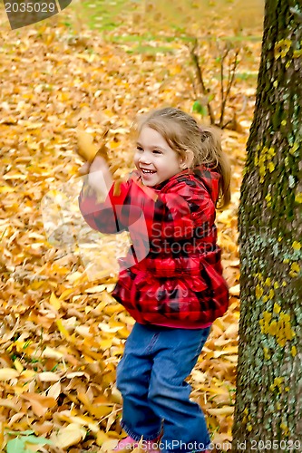 Image of Little girl playing with leaves