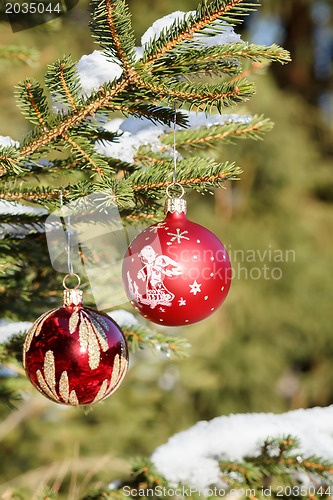 Image of christmas balls on outdoor snowy tree