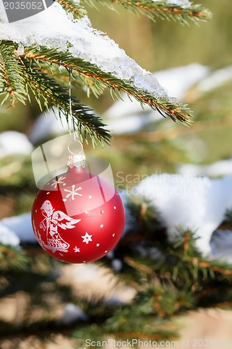 Image of christmas balls on outdoor snowy tree