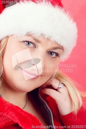 Image of Portrait of joyful pretty woman in red santa claus hat smiling