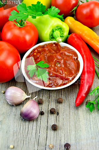 Image of Ketchup with vegetables and spices on an old board