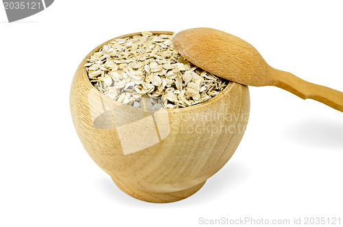 Image of Oat flakes in a wooden bowl with a spoon