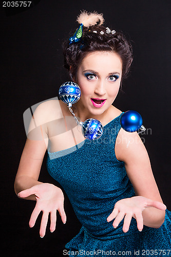 Image of beautiful girl playing with Christmas decoration