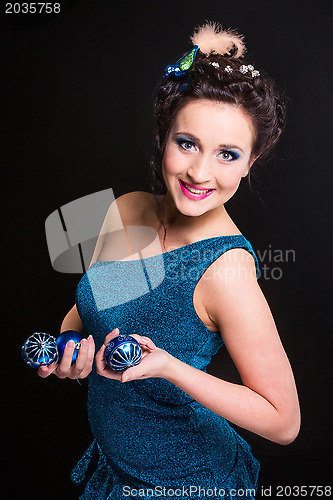 Image of beautiful girl playing with Christmas decoration