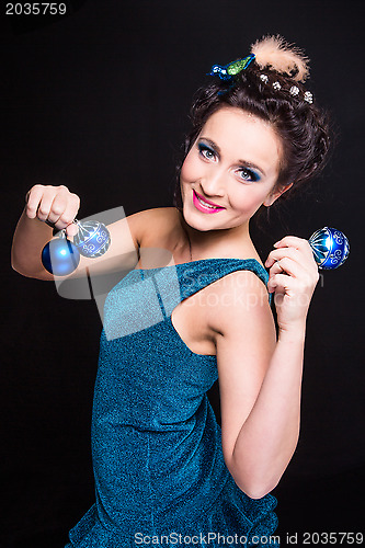 Image of beautiful girl playing with Christmas decoration