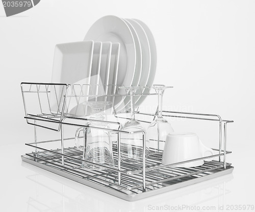 Image of White dishes drying on metal dish rack