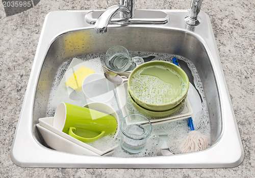 Image of Dishes soaking in the kitchen sink