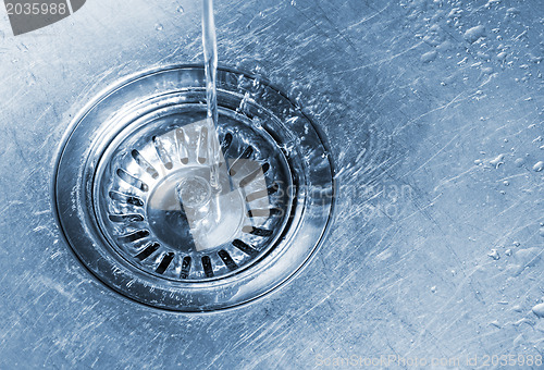 Image of Water running into kitchen sink drain