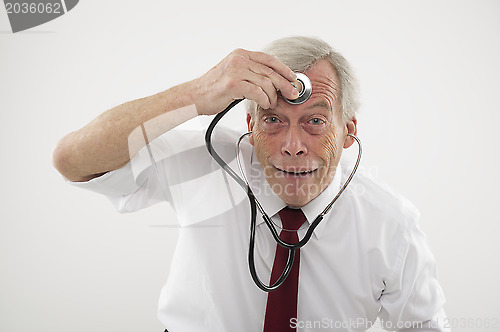 Image of Senior man holding a stethosope to his forehead