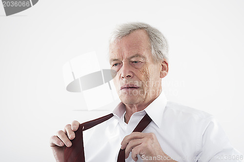 Image of Elderly man putting on his tie