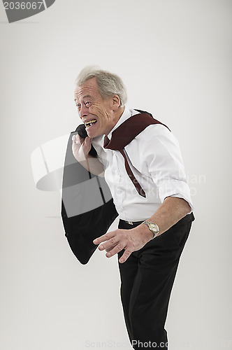 Image of Senior businessman leaning forwards into wind