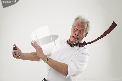 Image of Businessman being battered by strong winds