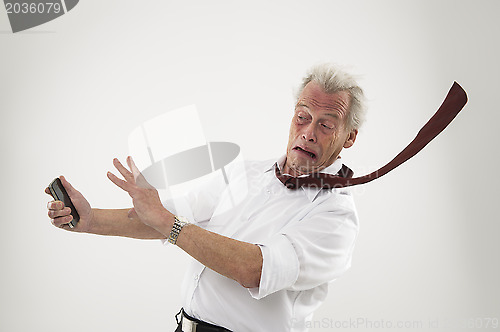 Image of Senior businessman in the teeth of a hurricane