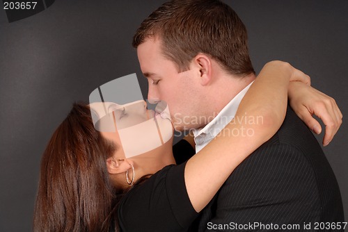Image of Attractive young couple in each others arms kissing