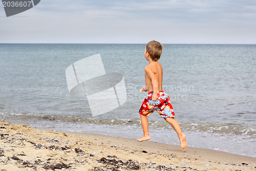 Image of Little boy running at the seashore