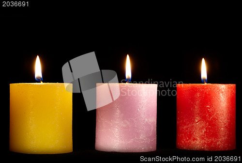 Image of Three candles on black.