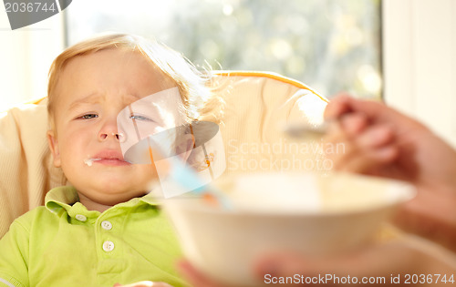 Image of Kid is very disappointmented about porridge.