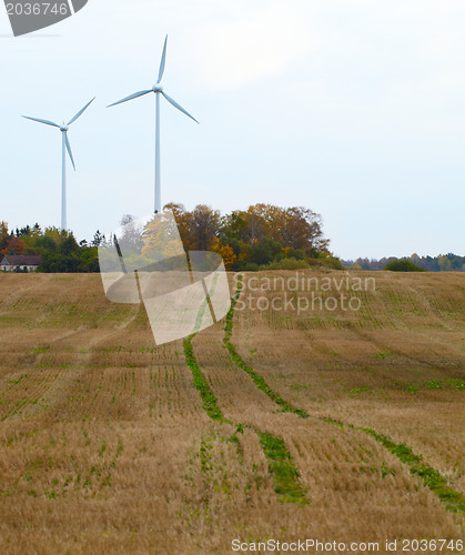 Image of Two wind turbines in the field.